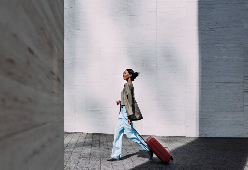 https://www.istockphoto.com/photo/confident-woman-walking-with-red-suitcase-in-modern-urban-setting-gm2155498773-576313079?searchscope=image%2Cfilm